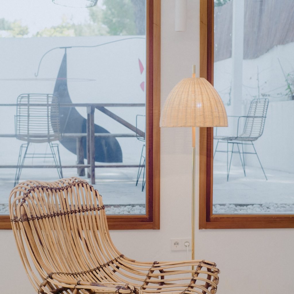 Elegant floor lamp with handwoven rattan shade and polished brass structure