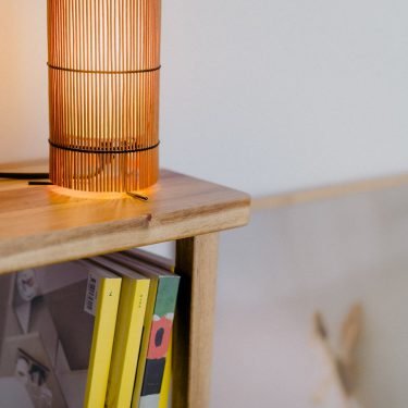 Foc Table Lamp with cherry-colored bamboo shade and black metal feet.