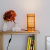 Foc Table Lamp with cherry-colored bamboo shade and black metal feet.