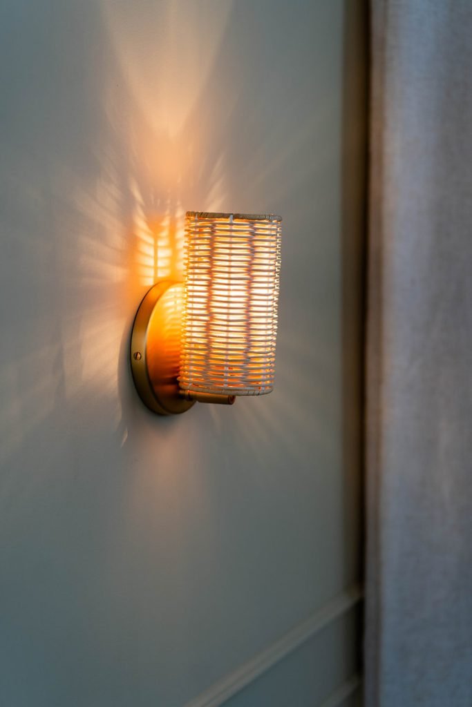 Handcrafted Costa Wall Lamp Mini Rattan Brass with natural rattan cylindrical shade.