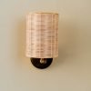 Handcrafted Costa Wall Lamp Cylindrical Rattan/Brass with a natural rattan cylindrical shade and brass accents.