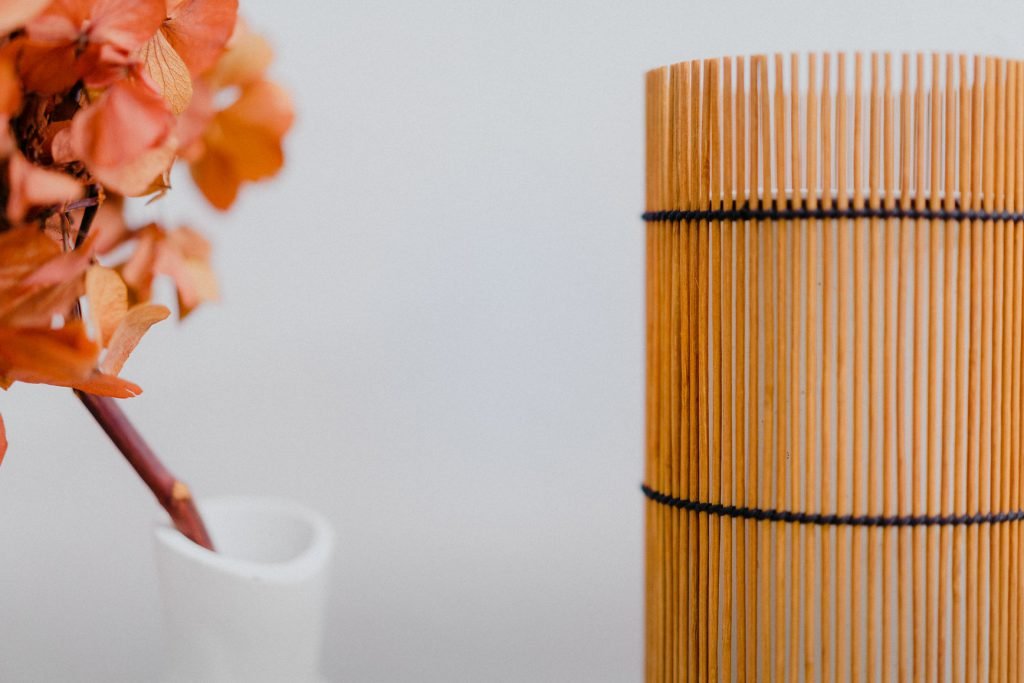 Foc Table Lamp with cherry-colored bamboo shade and black metal feet.