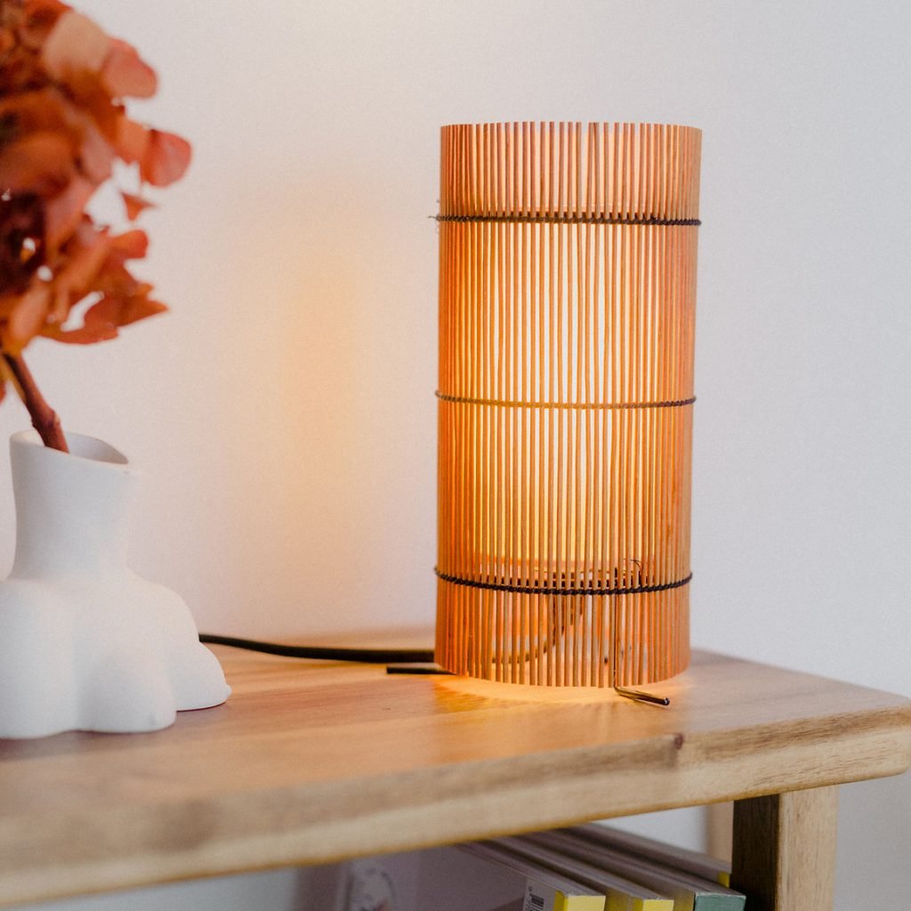 Foc Table Lamp with cherry-colored bamboo shade and black metal feet.